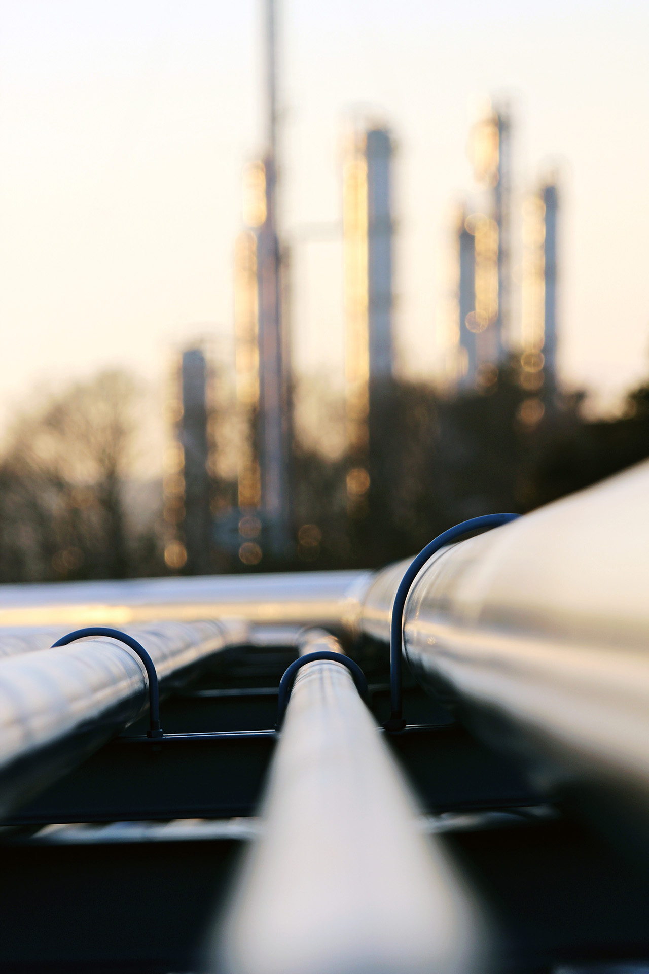 perspective of oil pipeline with refinery in background