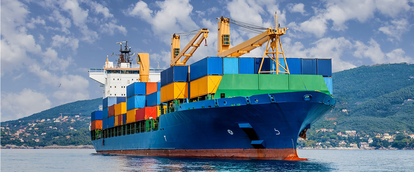 Cargo ship with colorful containers with landscape in background